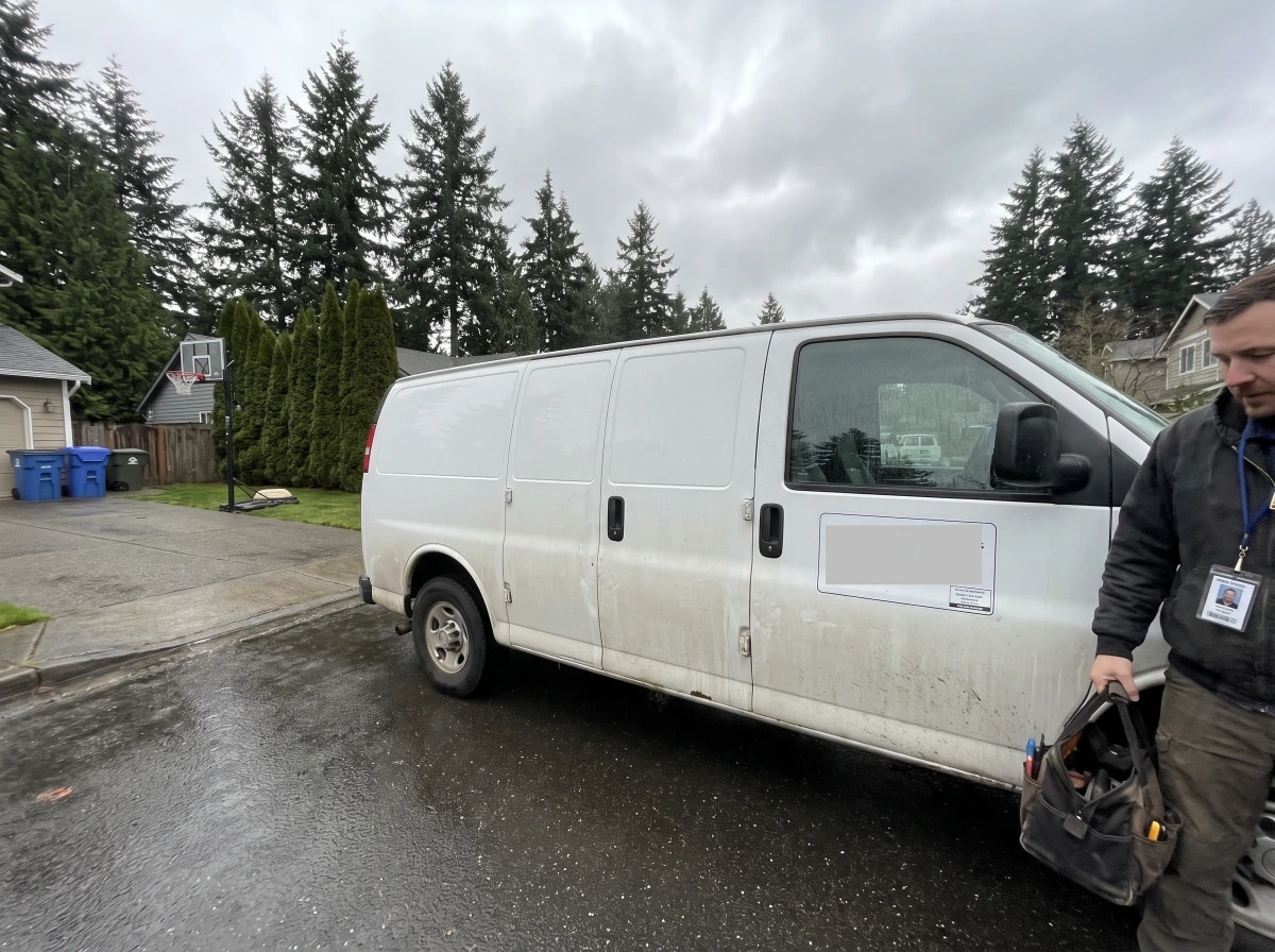 Locksmith retrieving a tool bag from the van for an emergency after-hours call